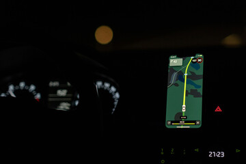 Aufkleber - A driver uses a GPS navigation system at night, displaying route information and speed while ensuring a safe journey