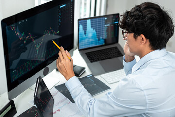 Wall Mural - Businessman investor working with computer, tablet and analyzing graph stock market trading planning with chart data financial investment planning