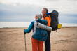 © Юлия Завалишина - Hiking tourism adventure. Senior couple man woman enjoying outdoor recreation hiking on beach. Happy old people backpackers hikers enjoy walking hike trekking tourism active vacation beauty of nature