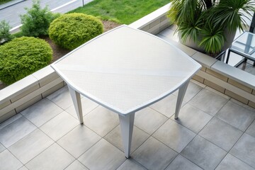 Modern outdoor table surrounded by lush green bushes.