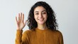 © indyntk - A confident Middle Eastern woman waving her hand with a warm smile, exuding friendliness on a solid white background