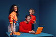 © Jacob Lund - Happy and diverse team celebrating achievement in bold colorful office