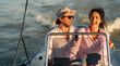 © DusanJelicic - A happy couple enjoying a boat ride on a sunny day, with the man wearing a hat and sunglasses and the woman laughing.