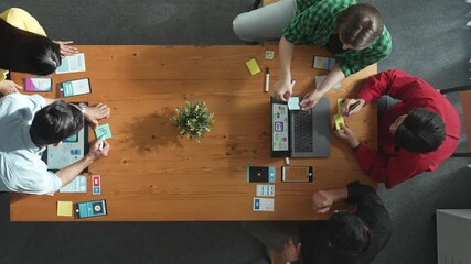 Programmer sharing Ux Ui design for mobile phone interface idea with software developer at meeting while designer writing idea at sticky notes. Start up team develop wireframe prototype. Convocation.
