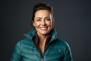 Poster - Portrait of a satisfied woman in her 40s donning a durable down jacket in front of pastel teal background