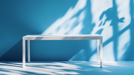 Wall Mural - Modern white table with shadow patterns on a blue wall in a well-lit contemporary room during daytime