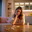 © AnyPic289 - Sad woman looks at medication on table in cozy home setting, symbolizing depression and healthcare.