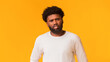© Prostock-studio - Indignant young african american man over orange studio background, copy space