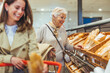 © Dragana Gordic - Smiling Women Shopping for Bread in a Supermarket