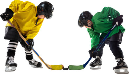 Two young hockey players, boys one in yellow and green uniform, face off with sticks hover near puck, ready for action isolated on transparent background. Concept of sport, childhood, active lifestyle