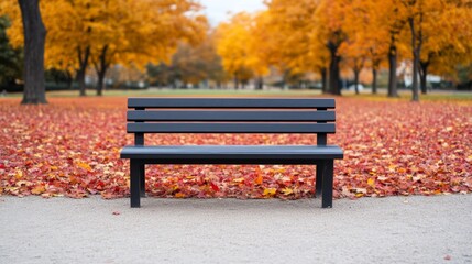 Sticker - Empty park bench surrounded by fallen red and yellow leaves, with tall maple trees in the background 