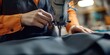 © Kamonwan - A tailor skillfully sewing fabric with a sewing machine in a workshop setting, highlighting craftsmanship and attention to detail.