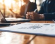 © DuangphonKPR - A business team reviewing bank approval terms, with documents and laptops spread across the table