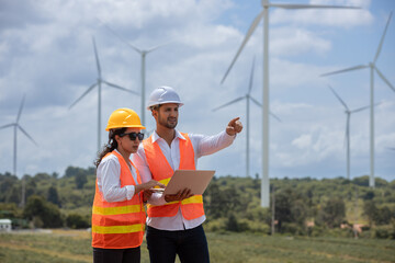 Fototapete - man and woman engineer worker wind turbine working laptop success agreement survey discuss operational planning. Windmill field clean energy sustainable clean. engineering nature power alternative.
