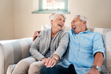 Wall Mural - Happy, laughing and senior couple on sofa for connection, bonding and relax together at home. Smile, love and elderly man and woman in retirement hugging, talking and resting in living room at house.