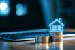 © enterdigital - A digital house icon above stacks of coins, symbolizing real estate investment and financial growth in a modern workspace.