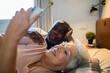 © Geber86 - Happy diverse senior couple taking selfie in bed at home