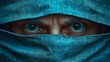 © ART IS AN EXPLOSION. - A man with blue eyes is looking at the camera through a blue cloth
