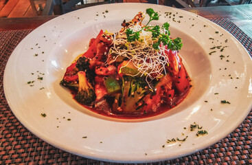 White plate with a chicken vegetable potato dish in Mexico.