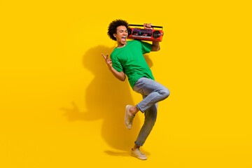 Poster - Full length photo of handsome good mood guy wear green t-shirt show v-sign enjoy boom box songs emtpy space isolated yellow color background