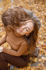 Wall Mural - Mother and her daughter sitting on a curb in autumn forest