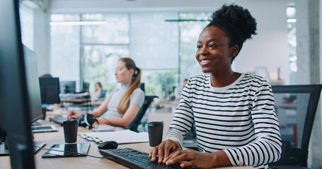 arican american woman with plastic cup of coffee sitting down on office chair. woman with smile star