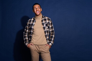 Canvas Print - Photo of attractive young man look empty space hands pockets dressed stylish checkered clothes isolated on dark blue color background