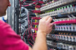 © Degimages - IT technician fixing computer, cables and hardware components on workbench.