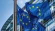© Franklin - Close-up view of European Union flags waving outside a modern building, representing European unity, governance, and diplomacy.