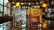 © Рудой Максим - Two cocktails served in glasses on a wooden table at a cozy bar during the evening, showcasing refreshing drinks with ice and lemon slices