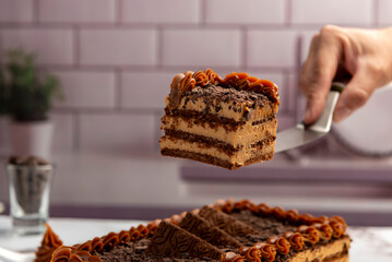 sweet dessert choco cake with chocolate cookies dulce de leche cream cheese on kitchen counter decorated with broken chocolate