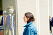 © Connect Images - Woman in blue jacket and glasses looking at a shop window display.