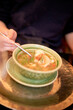 © Connect Images - A person enjoys a steaming bowl of shrimp pho with fresh herbs and lime in a cozy atmosphere.