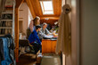 © Connect Images - Three people engaged in a study session at a wooden attic room with a bright window.