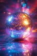 © Chawakorn - A disco ball with colorful lights reflecting on the floor.