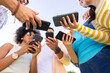 © wavebreak3 - Group of diverse friends holding smartphones, sharing and discussing content outdoors