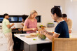 © wavebreak3 - Preparing food together, group of young diverse friends enjoying time in kitchen