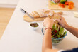 © wavebreak3 - Preparing fresh salad, person mixing vegetables in glass bowl on kitchen counter, copy space