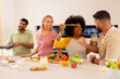 © wavebreak3 - Cooking together, diverse friends preparing meal in kitchen, smiling and laughing