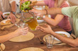 © wavebreak3 - Pouring iced tea into glass, diverse friends enjoying meal together at dining table