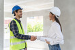 © Pormezz - construction worker and contractor. Client shaking hands with team builder in renovation site.