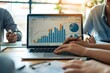 © Imagentive - Businesspeople Analyzing Financial Data on Laptop Screen with Graphs and Charts.