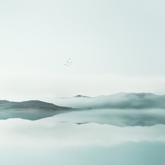 Canvas Print - A misty lake with mountains in the distance and a flock of birds flying overhead.