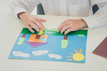 Poster - Portrait of cute charming pretty boy son wearing white shirt making origami illustrations colored carton handiwork indoors