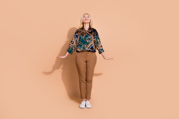 Wall Mural - Photo portrait of blonde hair happy mature worker lady in trendy garment looking above head new job vacancy isolated on beige color background