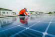 © ultramansk - engineer man inspects construction of solar cell panel or photovoltaic cell by electronic device. Industrial Renewable energy of green power. factory worker working on tower roof.