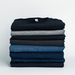 © Kakabe - A stack of neatly folded shirts in shades of black, gray, and blue against a white background ideal for fashion, retail, organization, or laundry themes