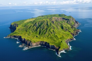 An aerial perspective of a green island with steep cliffs and stunning ocean views. The island is surrounded by deep blue waters, showcasing natural beauty and serenity.