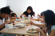 © Ladanifer - Latin family enjoying a meal together at their dining room table