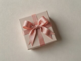 Wall Mural - Gift box wrapped with a pastel pink bow on a white background.